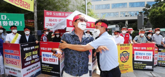 8월 17일 오후 정부세종청사 국토교통부 앞에서 열린 한국공인중개사협회 중개보수 인하 반대 기자회견에서 한 참석자가 "할복하고 싶은 심정"이라며 음료수병으로 본인의 머리를 내리치자 동료가 말리고 있다. <연합뉴스>